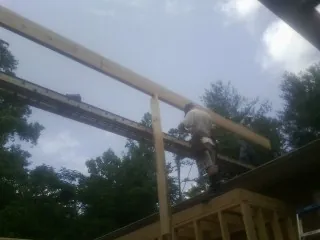 Carpenter setting a ridge beam over a new addition frame — Ice Dam Removal by Roofing Brothers in Strabane