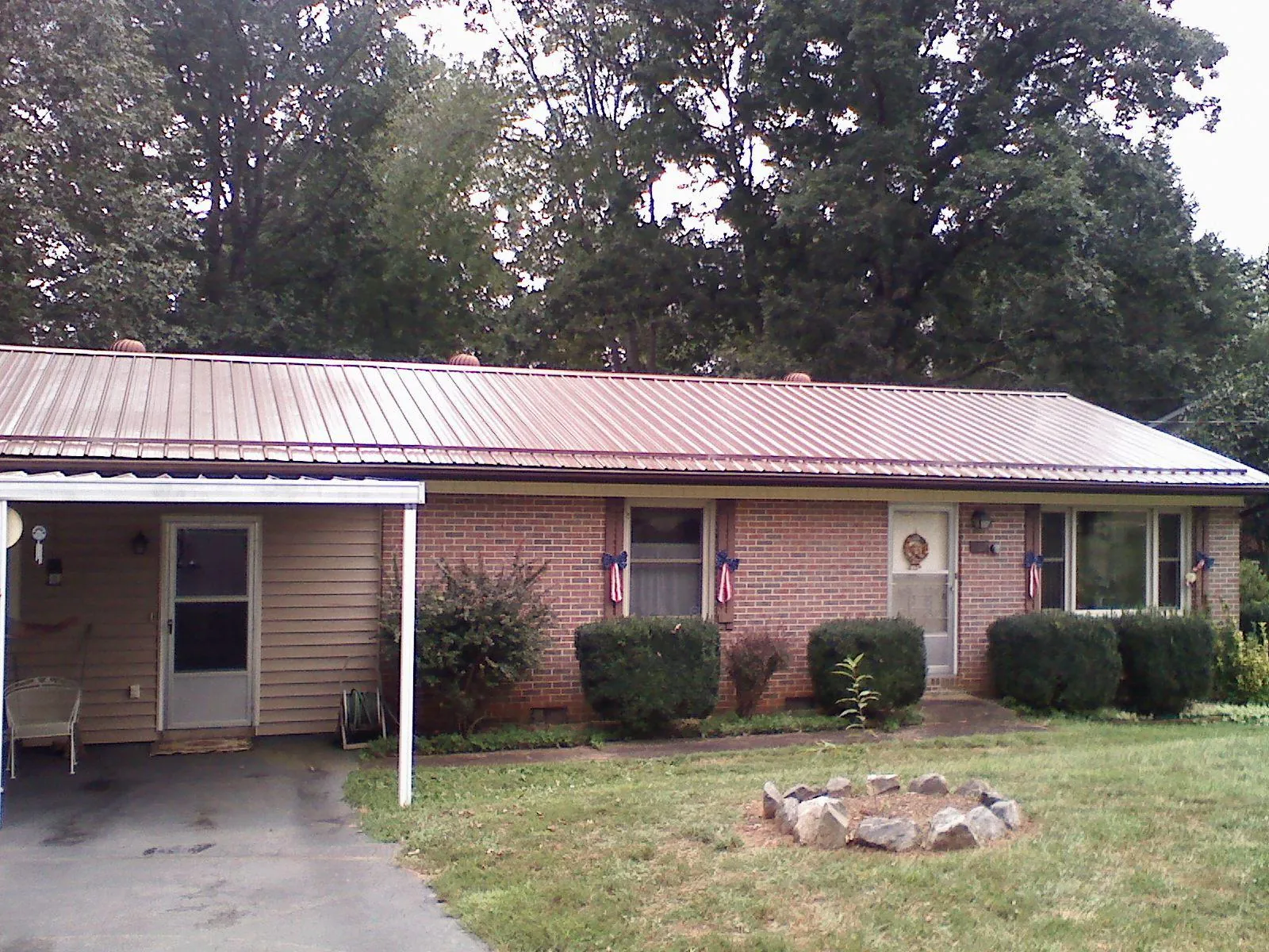 Bronze metal roof and carport on a brick ranch home — Roof Repair work by our crew in Strabane